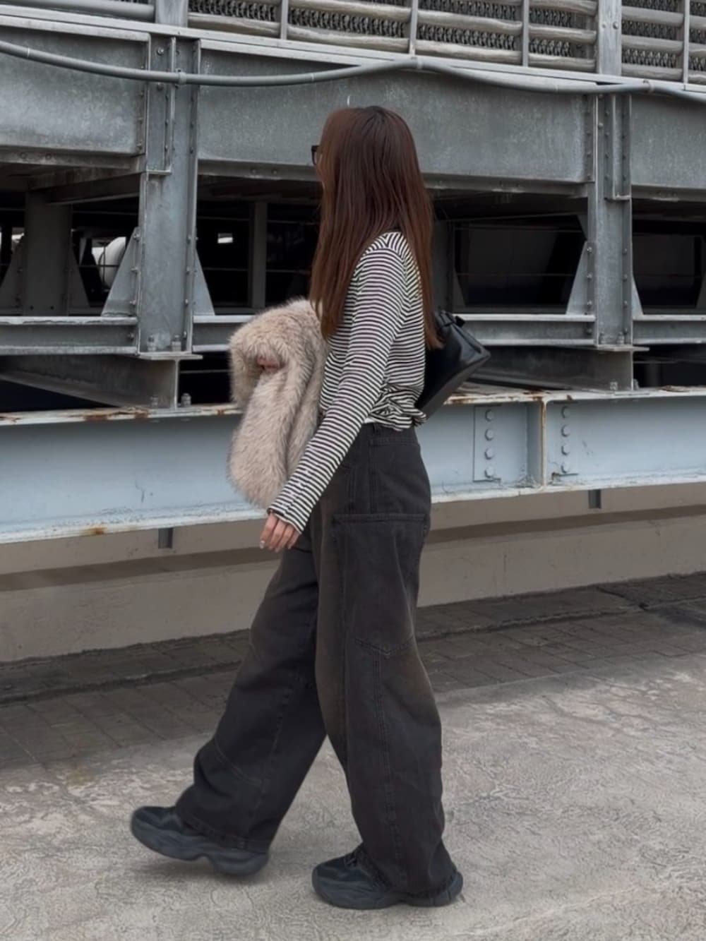 ブラック系のデニムパンツ、ホワイト系のTシャツ/カットソー、ブラック系のデニムパンツを着用したレディースの冬コーディネートの2枚目の写真