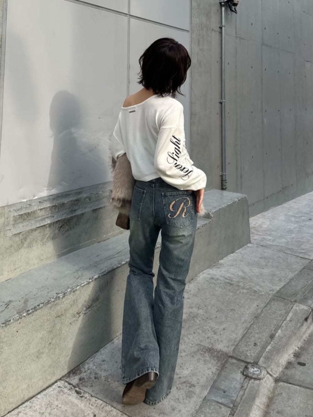 ブルー系のデニムパンツ、ホワイト系のTシャツ/カットソーを着用したレディースの冬コーディネートの2枚目の写真