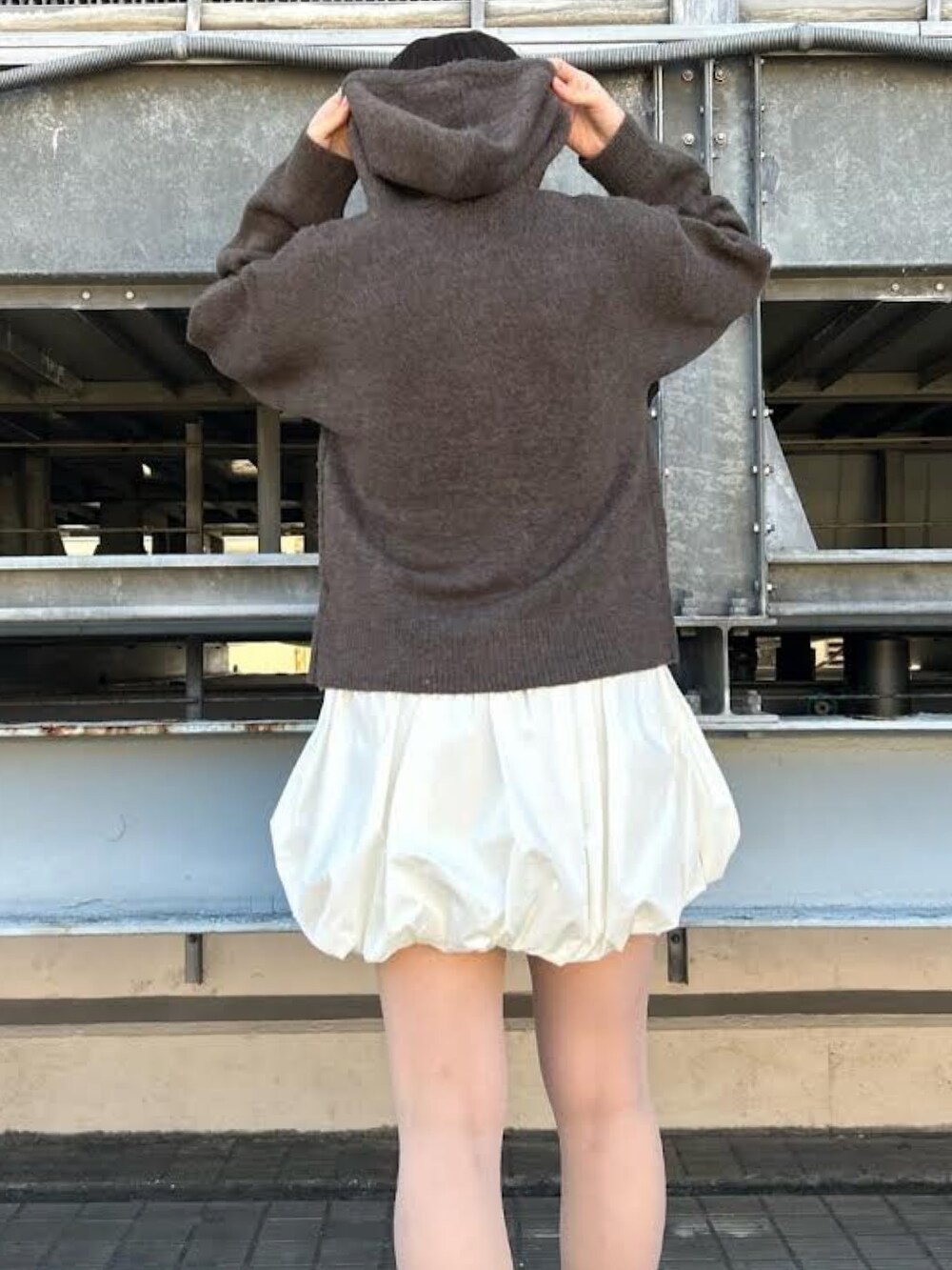 グレー系のニット/セーター、ホワイト系のスカートを着用したレディースの冬コーディネートの3枚目の写真