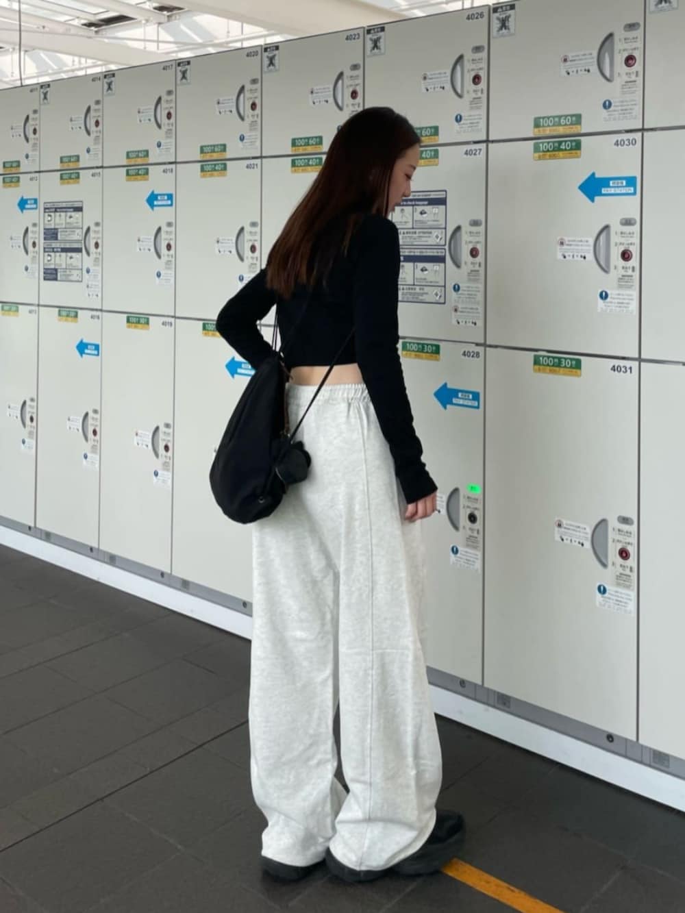 ブラック系のTシャツ/カットソー、ホワイト系のスウェットパンツを着用したレディースの秋コーディネートの3枚目の写真