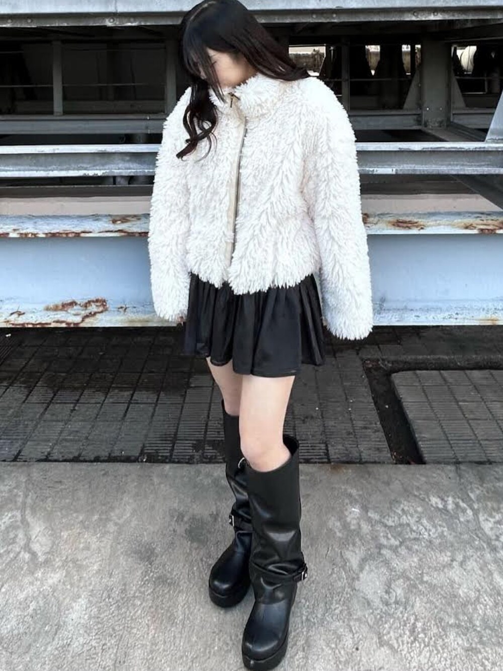 ホワイト系のブルゾン、ブラック系のブーツ、ブラック系のスカートを着用したレディースの冬コーディネートの2枚目の写真
