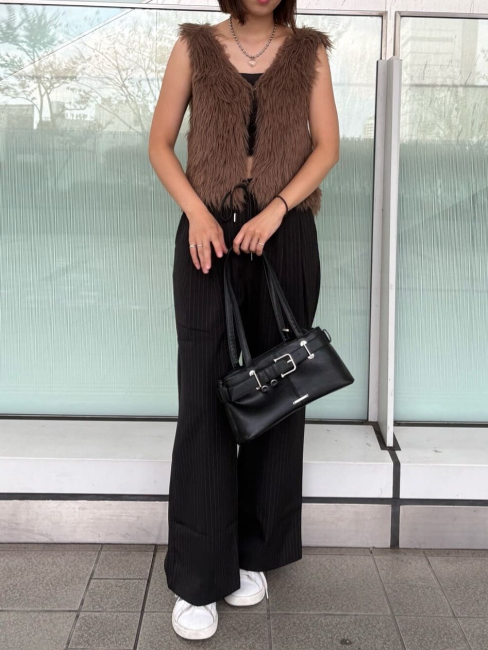 ブラック系のスラックス、ブラウン系のニット/セーターを着用したレディースの秋コーディネートの2枚目の写真