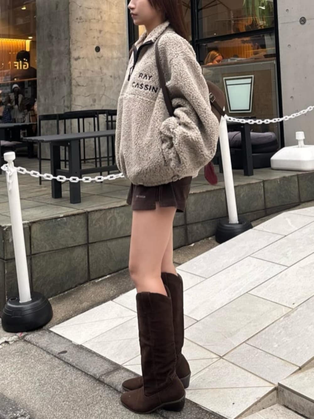 ブラウン系のブーツ、ベージュ系のスウェット、ブラウン系のスカートを着用したレディースの冬コーディネートの3枚目の写真