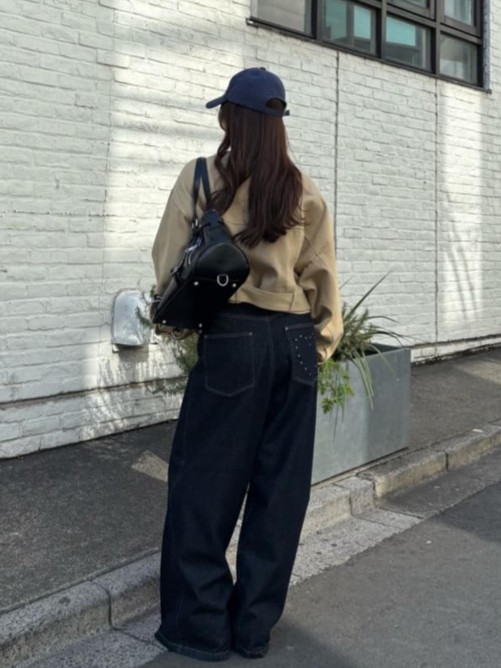ブルー系のデニムパンツ、ブラック系のキャミソール、ベージュ系のその他アウターを着用したレディースの冬コーディネートの2枚目の写真
