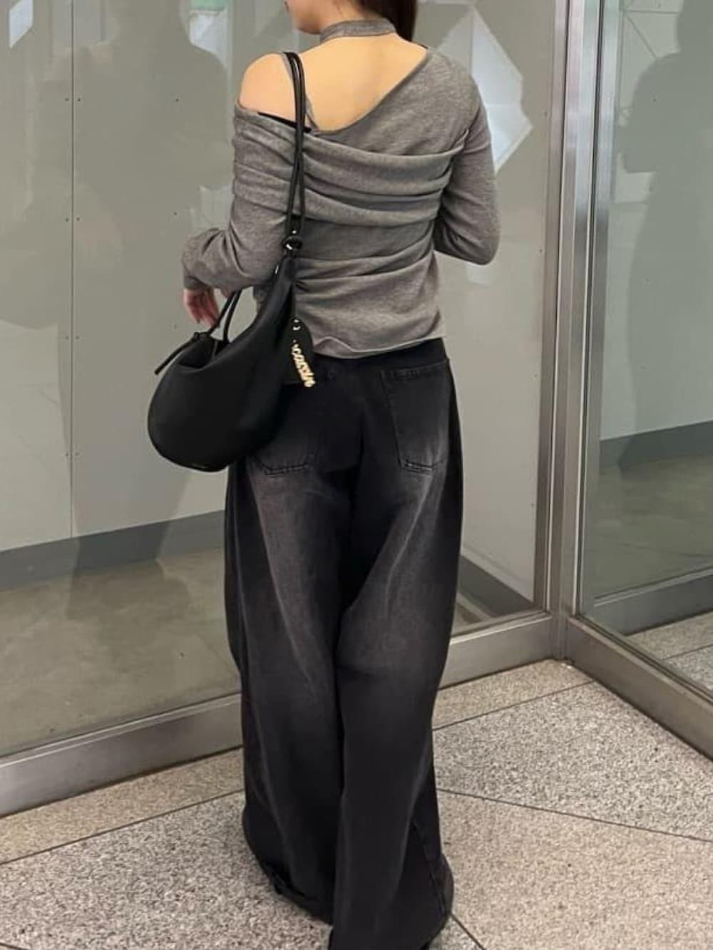 グレー系のニット/セーター、ブラック系のデニムパンツを着用したレディースの秋コーディネートの3枚目の写真