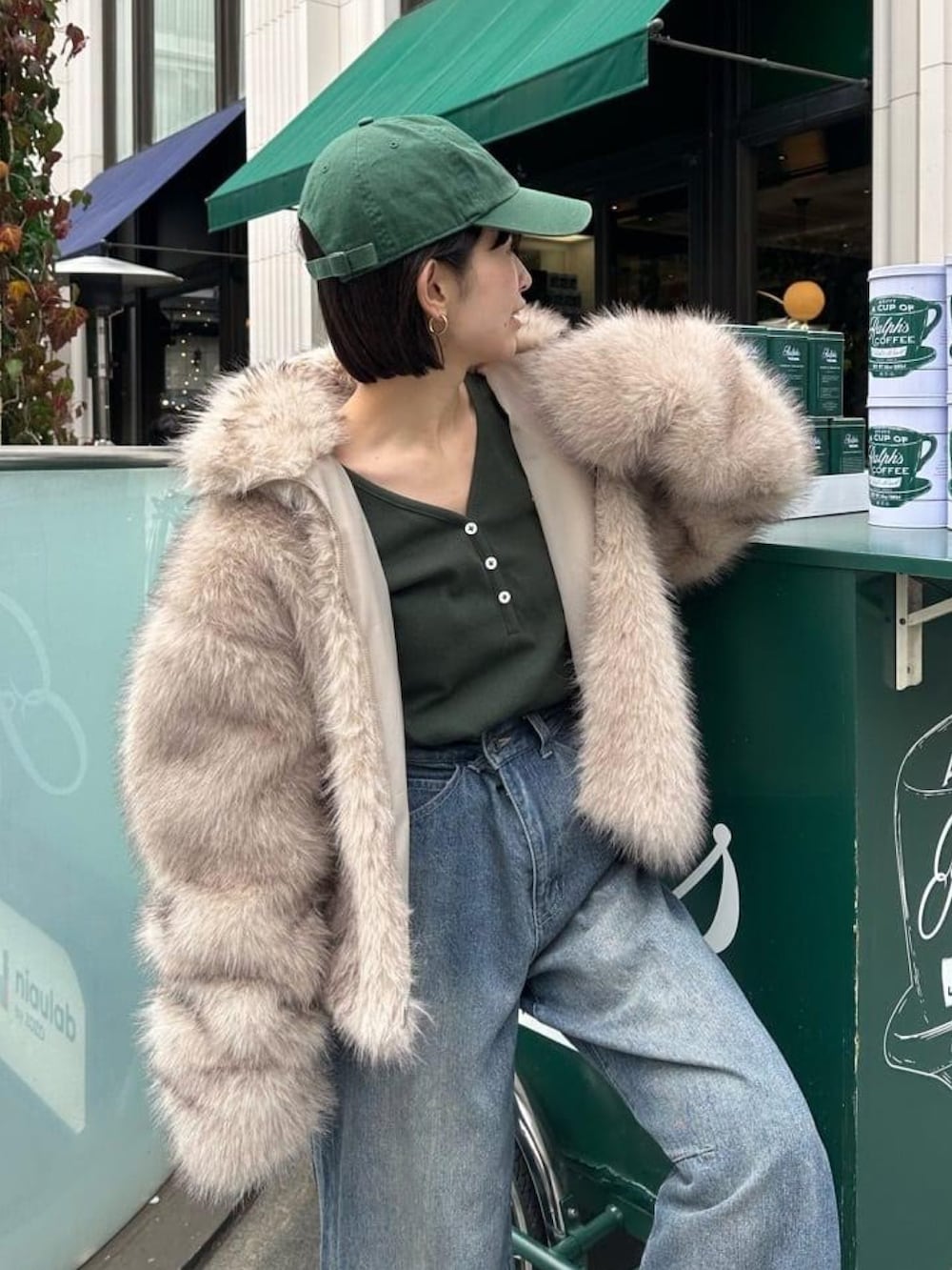 グリーン系のTシャツ/カットソー、ブラウン系のデニムスカートを着用したレディースの冬コーディネートの2枚目の写真