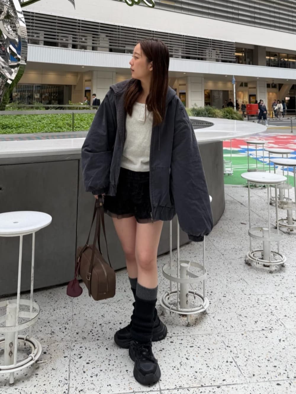 ブラック系のスカート、グレー系のブルゾン、ホワイト系のTシャツ/カットソーを着用したレディースの秋コーディネートの3枚目の写真