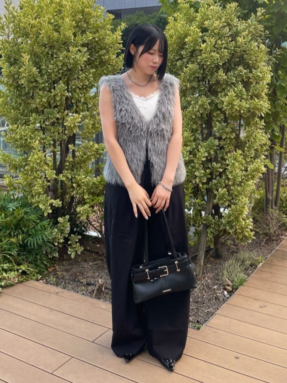 ホワイト系のキャミソール、ブラック系のスラックス、グレー系のニット/セーターを着用したレディースの秋コーディネートの2枚目の写真