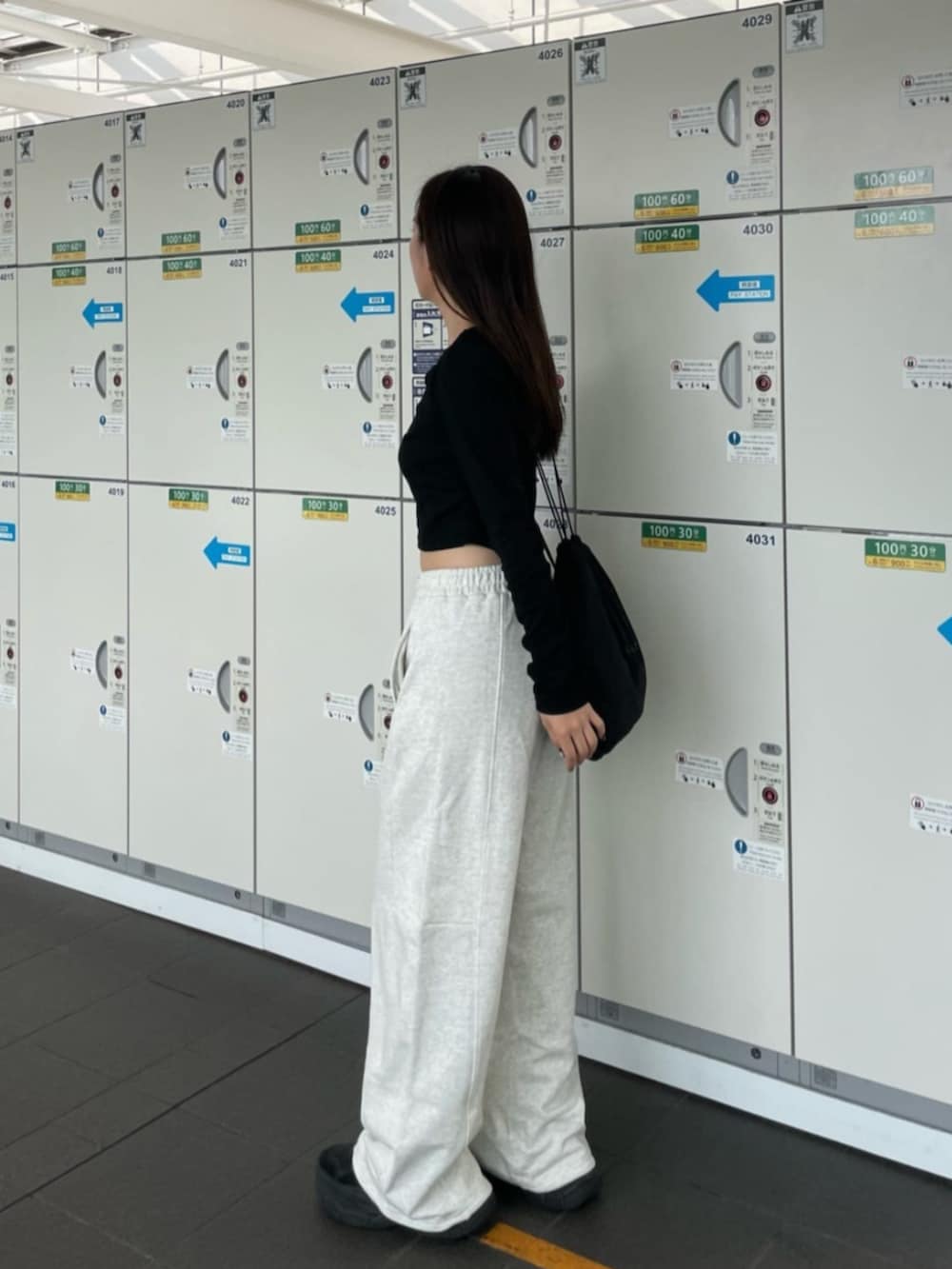 ブラック系のTシャツ/カットソー、ホワイト系のスウェットパンツを着用したレディースの秋コーディネートの2枚目の写真