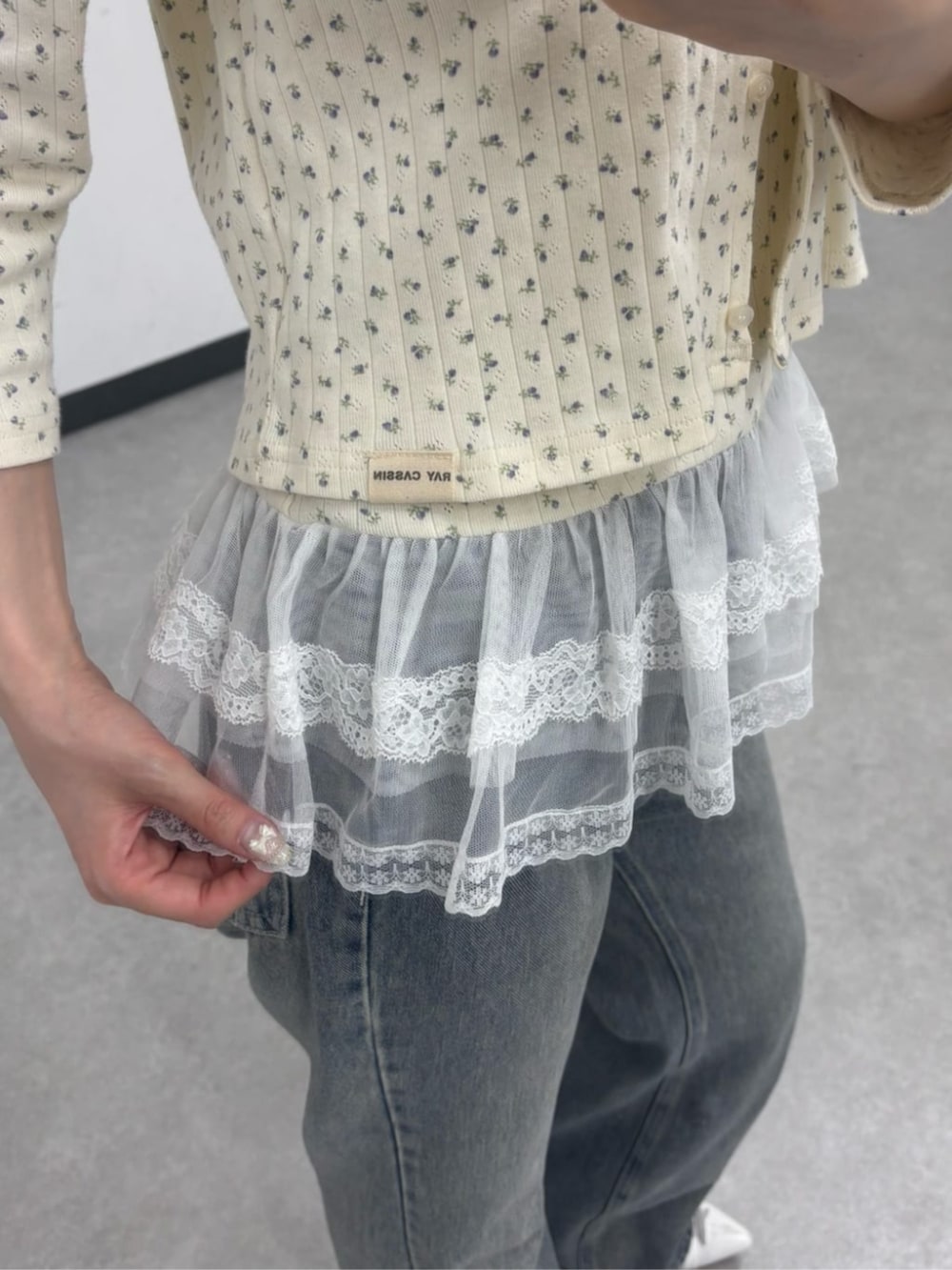 ブルー系のデニムパンツ、ホワイト系のサンダル、ホワイト系のカーディガン/ボレロを着用したレディースの春コーディネートの5枚目の写真