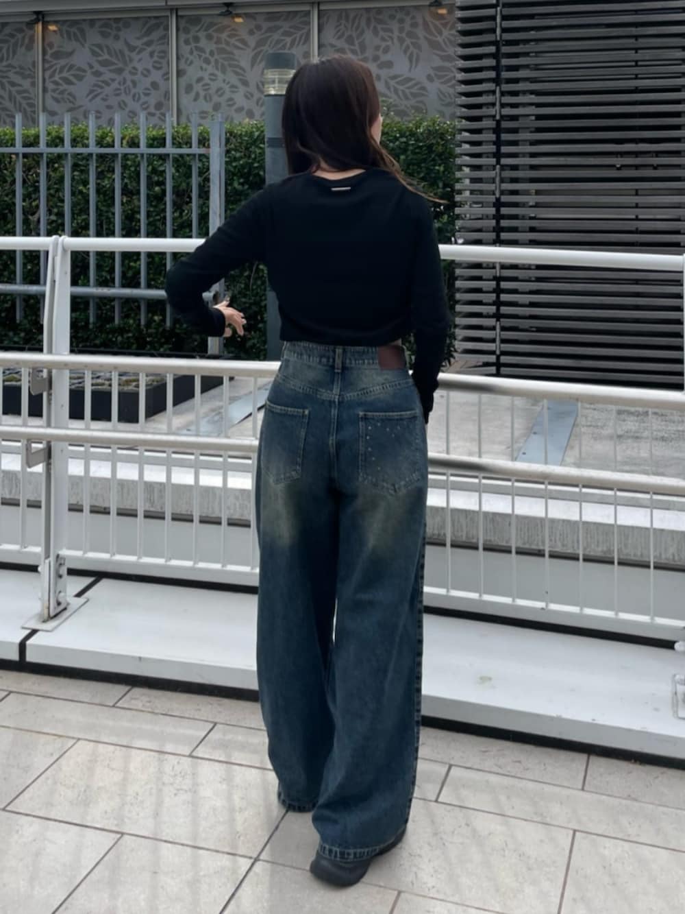 ブラック系のTシャツ/カットソー、ブルー系のデニムパンツを着用したレディースの秋コーディネートの3枚目の写真