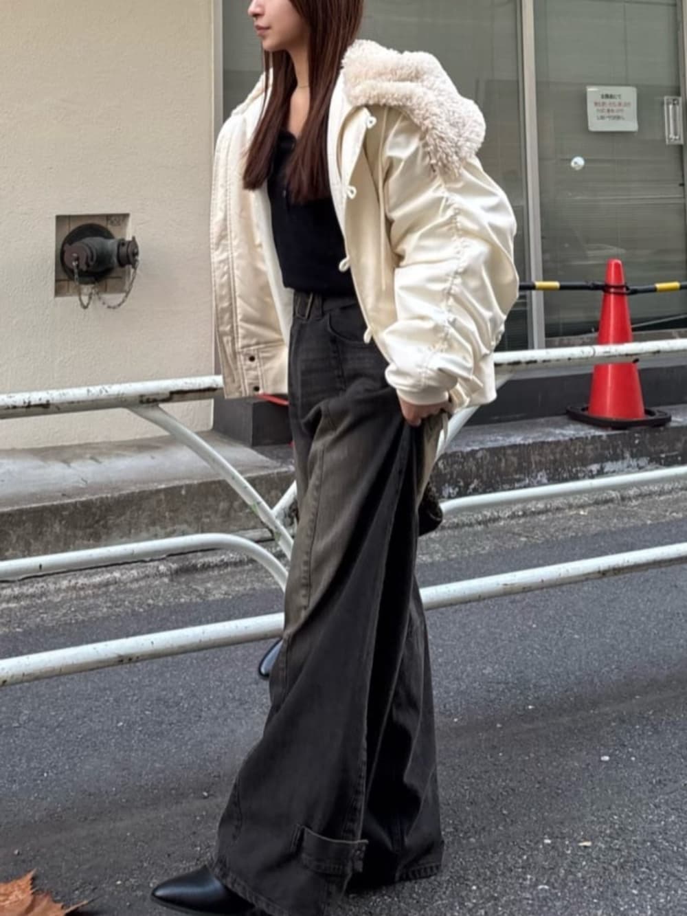 ブラック系のデニムパンツ、ホワイト系のブルゾンを着用したレディースの冬コーディネートの3枚目の写真