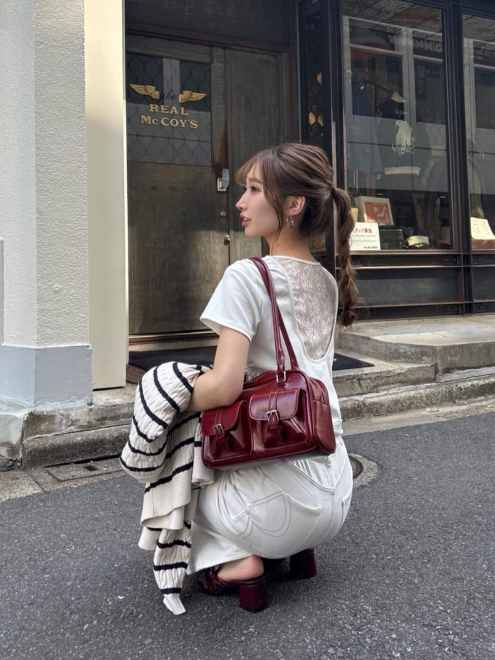 ブルー系のデニムパンツ、ホワイト系のTシャツ/カットソー、ホワイト系のサンダルを着用したレディースの夏コーディネートの5枚目の写真