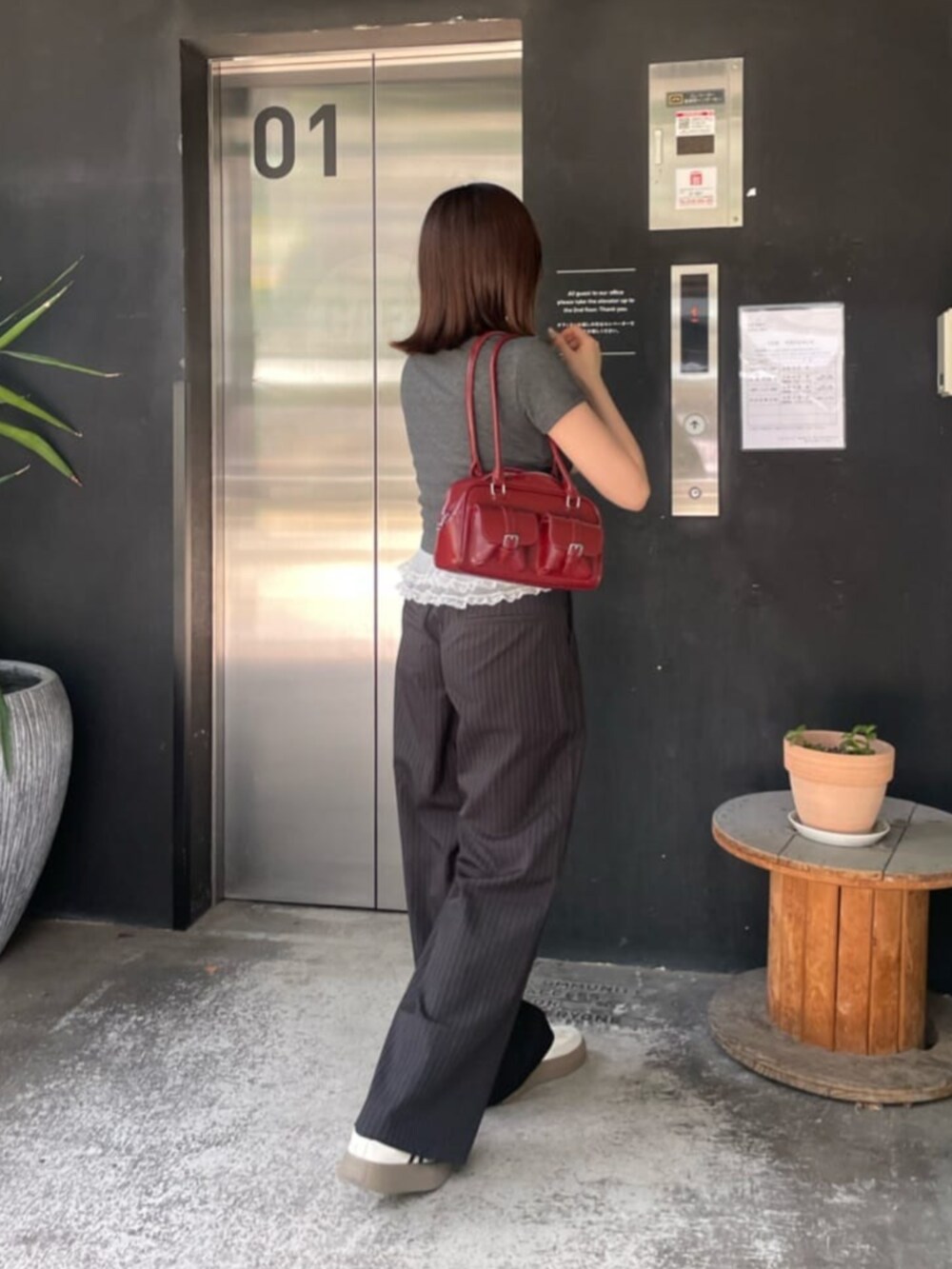 ブラック系のスラックス、グレー系のTシャツ/カットソーを着用したレディースの秋コーディネートの3枚目の写真