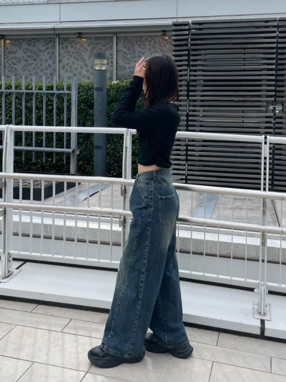 ブラック系のTシャツ/カットソー、ブルー系のデニムパンツを着用したレディースの秋コーディネートの2枚目の写真