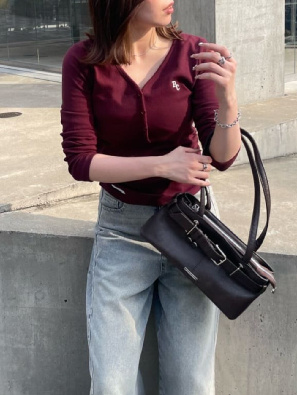 ブラック系のその他シューズ、ブルー系のデニムパンツ、ブラウン系のショルダーバッグを着用したレディースの秋コーディネートの2枚目の写真