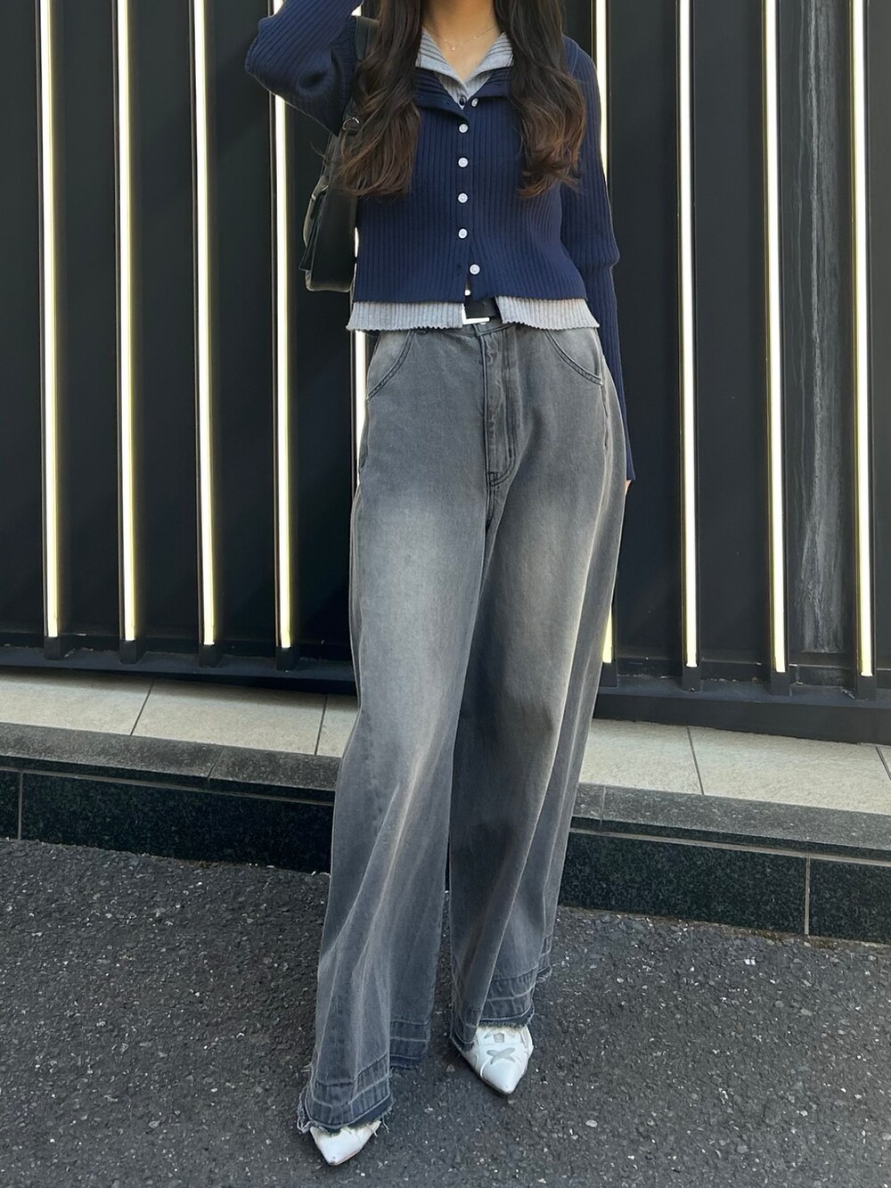 グレー系のデニムパンツ、ホワイト系のサンダル、レッド系のニット/セーターを着用したレディースの冬コーディネートの3枚目の写真