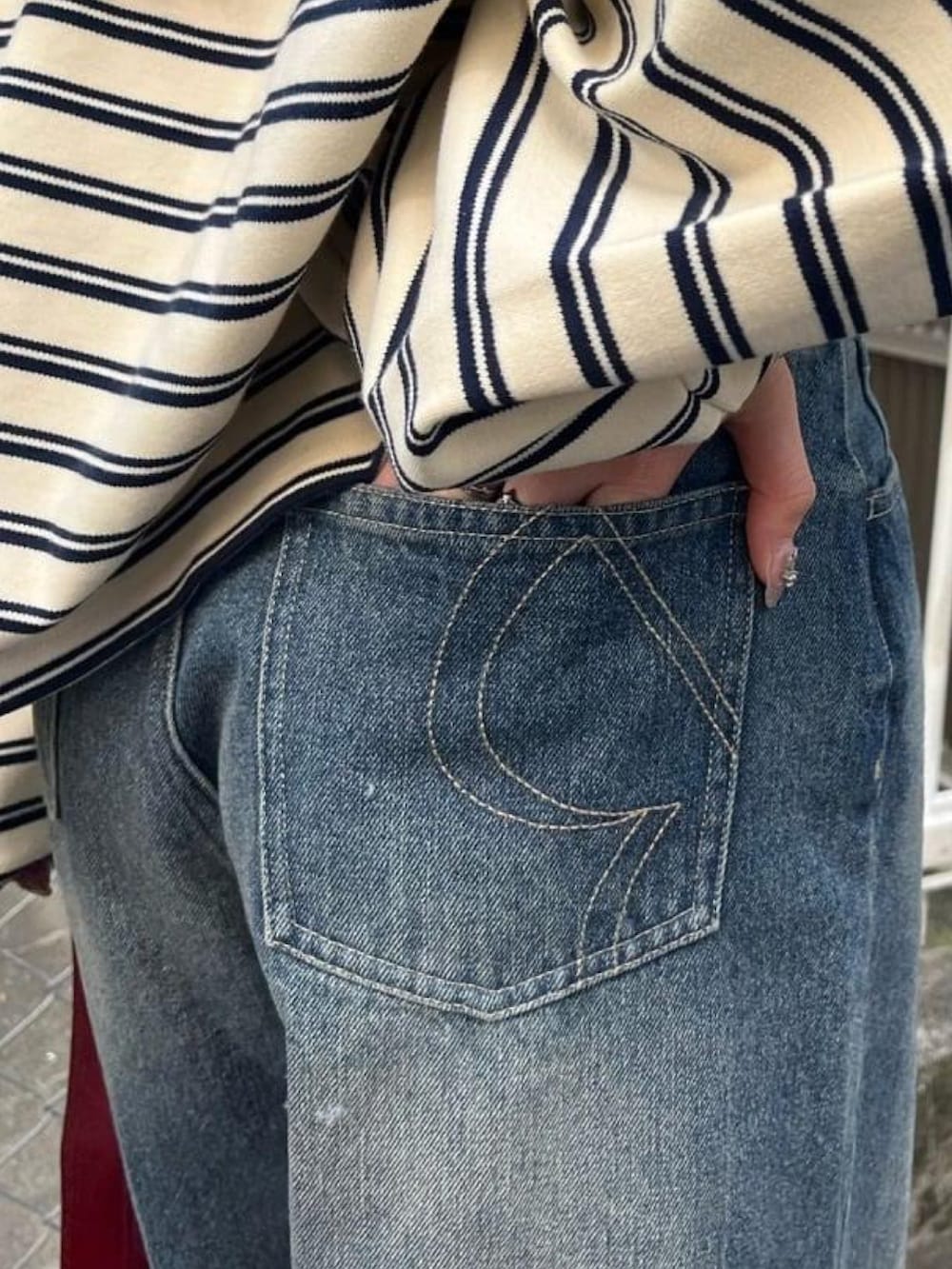 ブルー系のデニムパンツ、シルバー系のスニーカー、ホワイト系のTシャツ/カットソーを着用したレディースの冬コーディネートの3枚目の写真