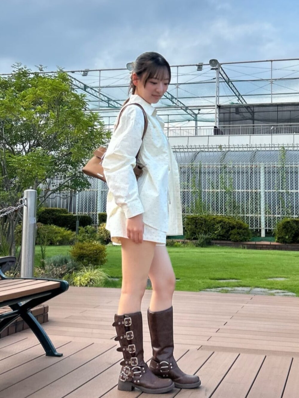 ブラウン系のブーツ、ホワイト系のキャミソール、ホワイト系のシャツ/ブラウスを着用したレディースの秋コーディネートの2枚目の写真