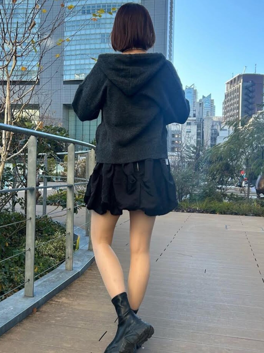 グレー系のニット/セーター、ブラック系のスカートを着用したレディースの冬コーディネートの2枚目の写真