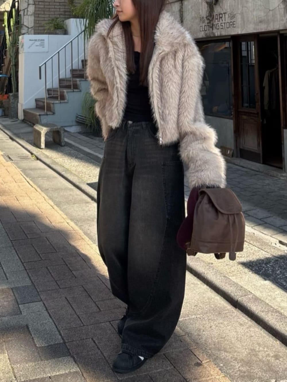 ブラック系のデニムパンツを着用したレディースの冬コーディネートの3枚目の写真