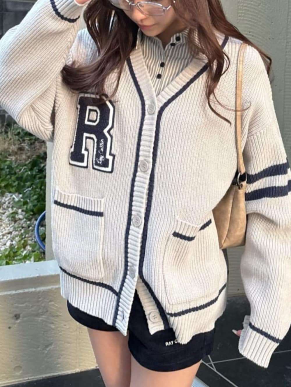 ホワイト系のシャツ/ブラウス、ホワイト系のカーディガン/ボレロ、ブラック系のスニーカーを着用したレディースの冬コーディネートの3枚目の写真