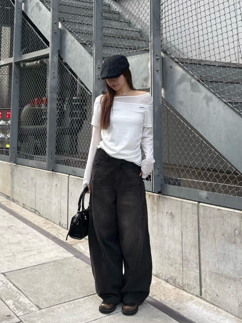 ブラック系のデニムパンツ、ブラック系のショルダーバッグ、ホワイト系のTシャツ/カットソーを着用したレディースの春コーディネートの2枚目の写真