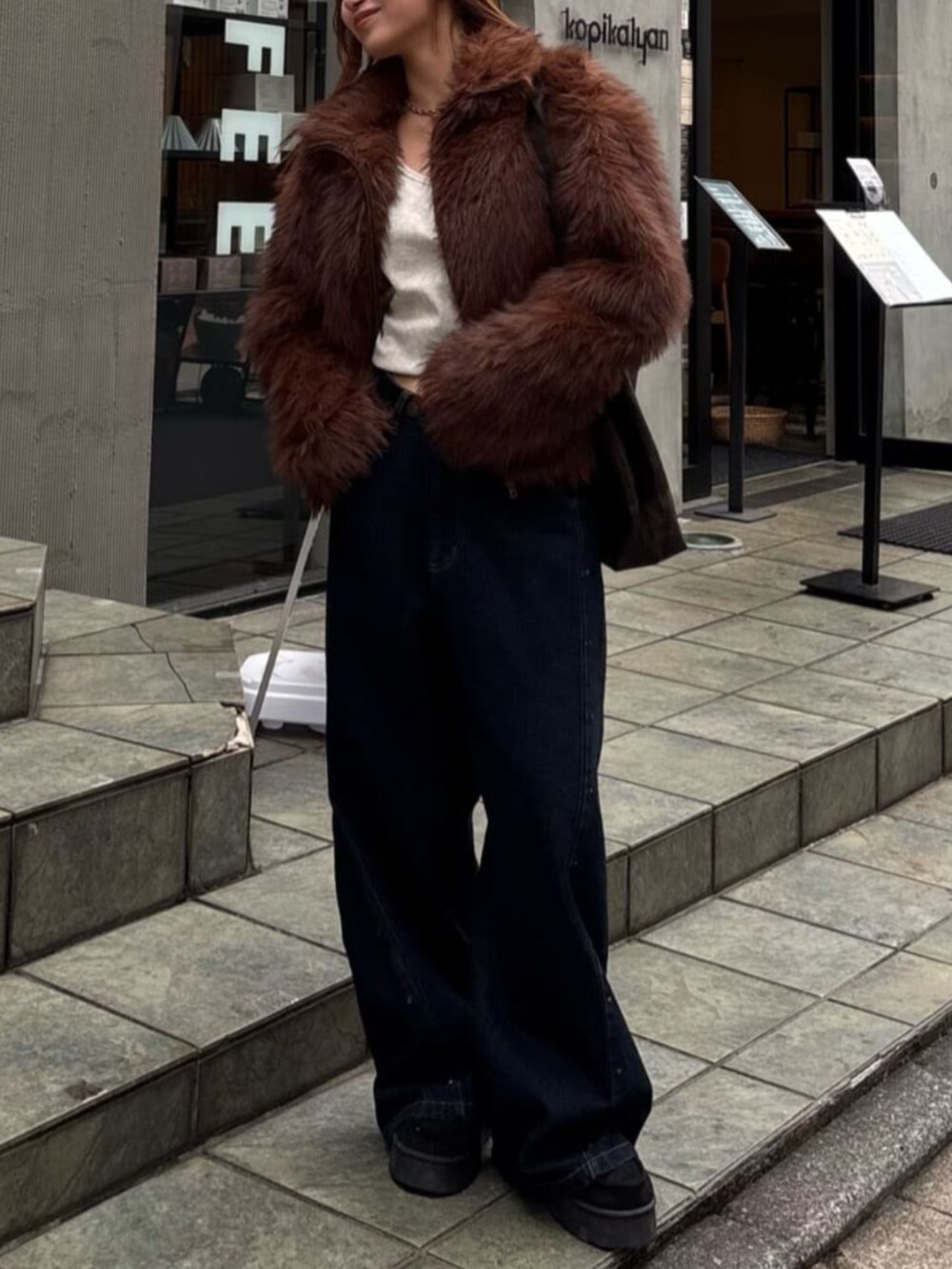ブルー系のデニムパンツ、ブラック系のその他シューズ、ブラウン系のブルゾンを着用したレディースの秋コーディネートの2枚目の写真