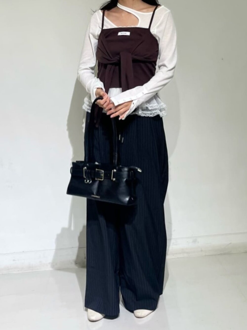 ホワイト系のTシャツ/カットソー、ブラウン系のキャミソールを着用したレディースの秋コーディネートの2枚目の写真