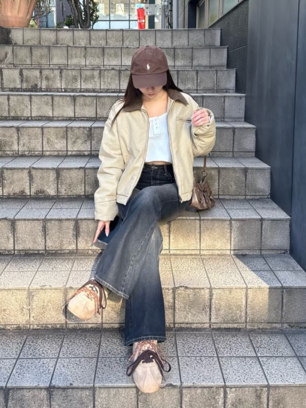 ベージュ系のスニーカー、ホワイト系のTシャツ/カットソー、ベージュ系のブルゾンを着用したレディースの冬コーディネートの2枚目の写真