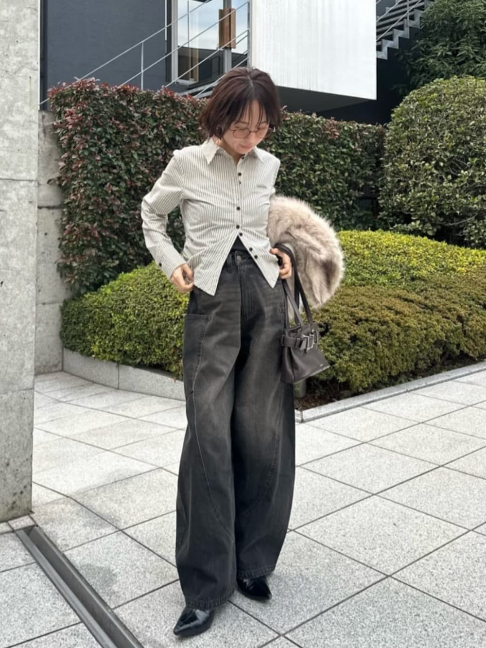 ブラック系のデニムパンツ、ホワイト系のシャツ/ブラウスを着用したレディースの春コーディネートの2枚目の写真