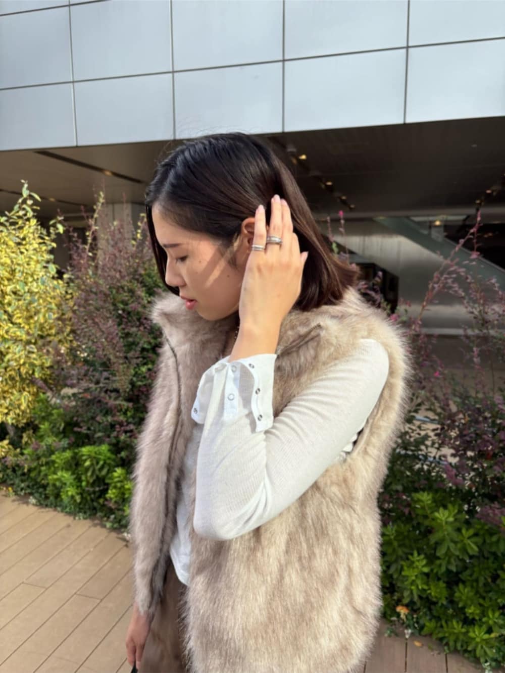 ホワイト系のベスト、ホワイト系のTシャツ/カットソー、ベージュ系のスカートを着用したレディースの秋コーディネートの2枚目の写真