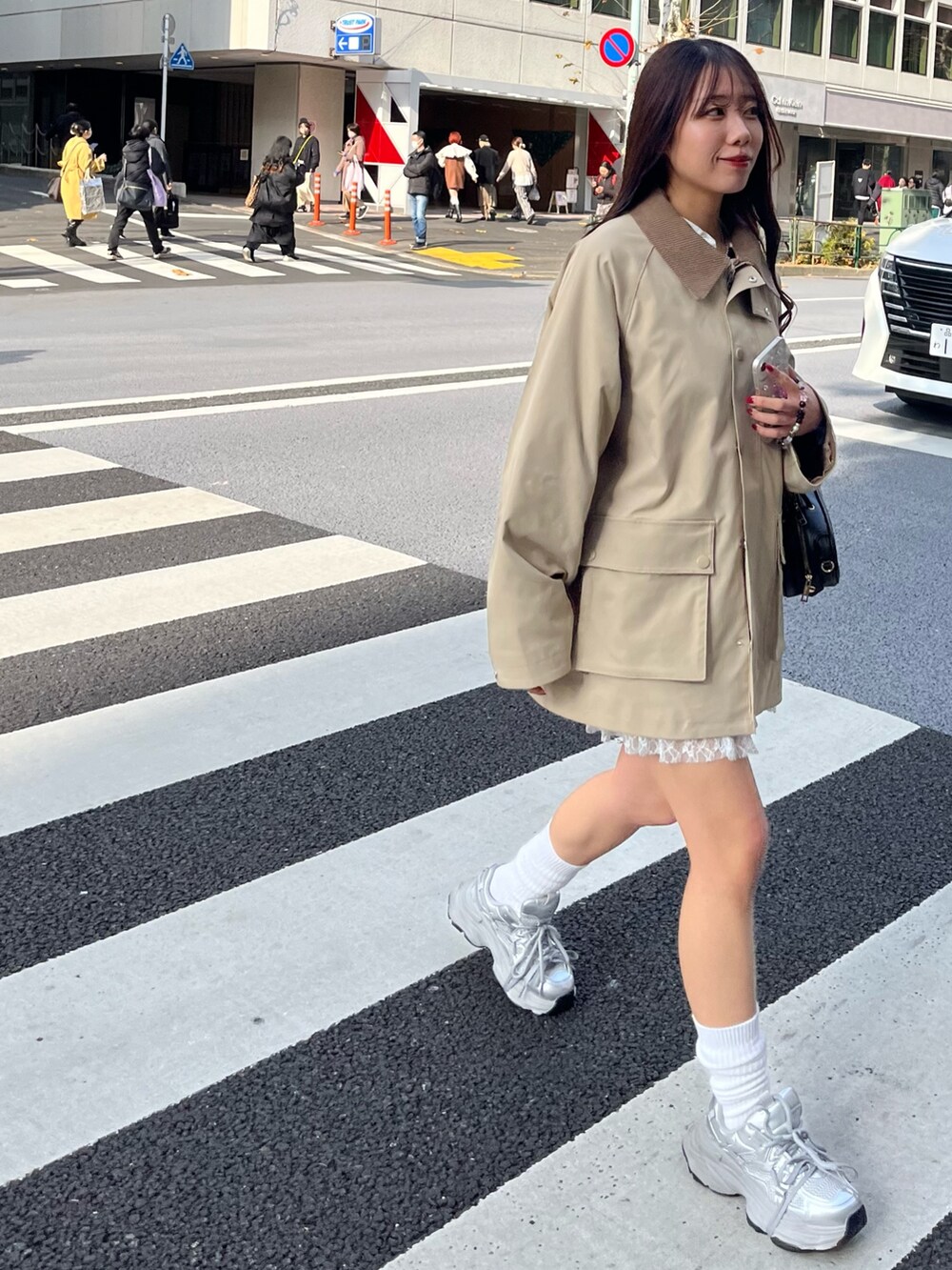 ベージュ系のテーラードジャケット、ホワイト系のTシャツ/カットソー、ホワイト系のスカートを着用したレディースの冬コーディネートの2枚目の写真