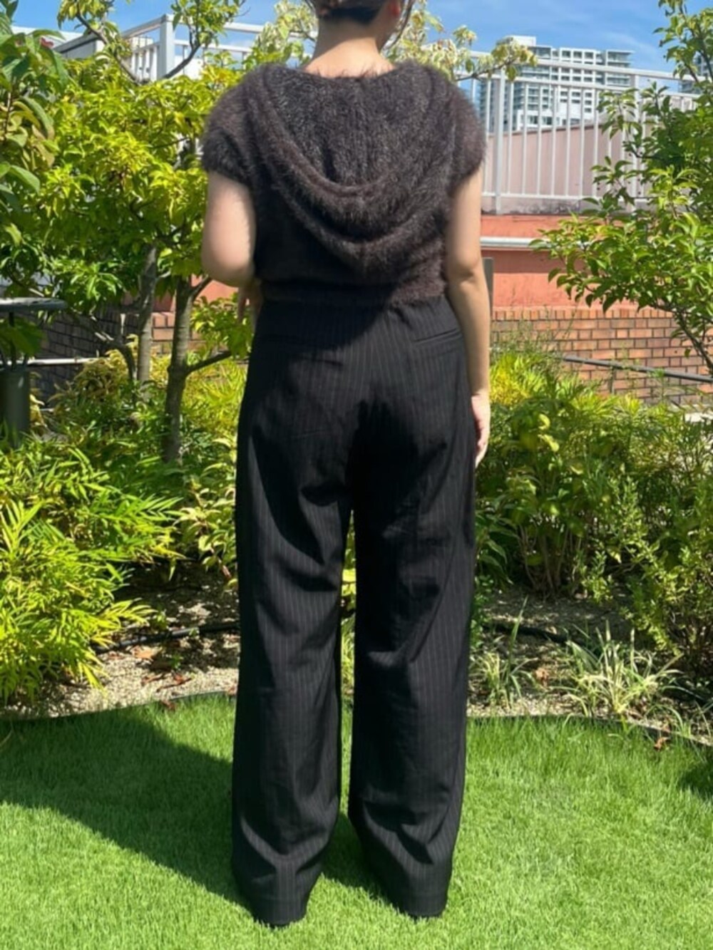 ブラック系のスラックス、グレー系のニット/セーターを着用したレディースの秋コーディネートの2枚目の写真