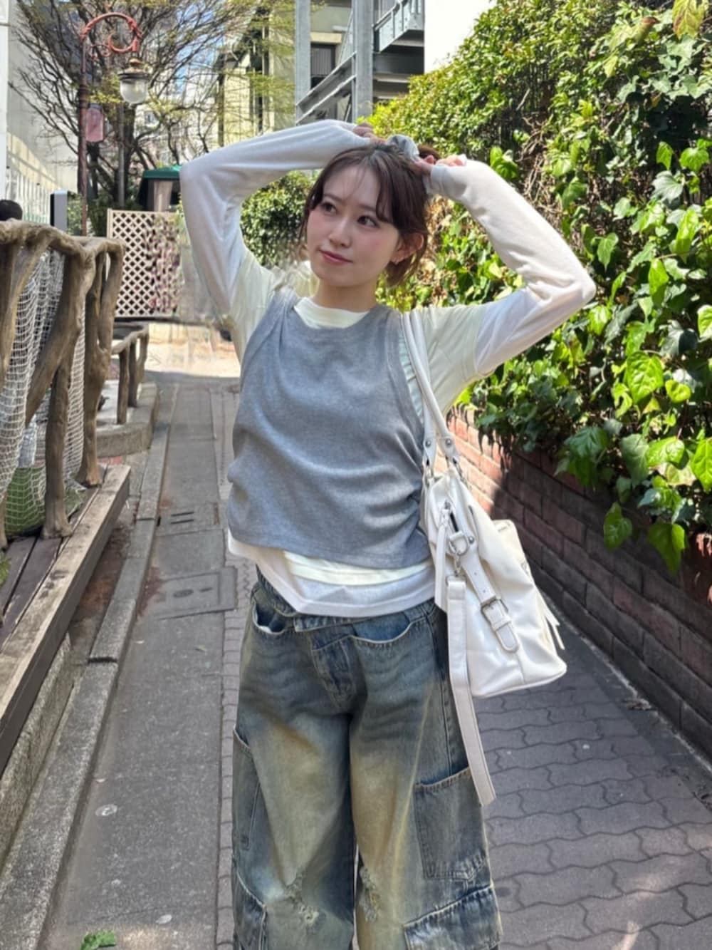 グレー系のTシャツ/カットソー、ブルー系のデニムパンツを着用したレディースの春コーディネートの2枚目の写真