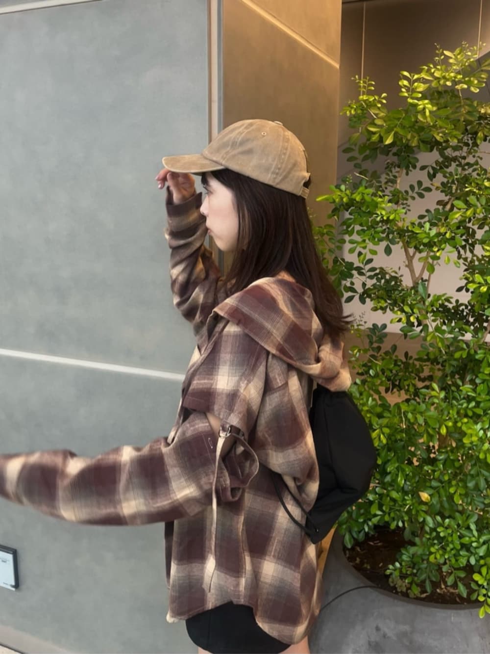 ブラウン系のシャツ/ブラウス、ブラック系のスカート、ブラウン系のブーツを着用したレディースの秋コーディネートの2枚目の写真