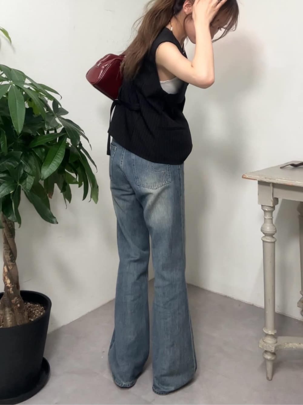 ブルー系のデニムパンツ、ブラック系のベストを着用したレディースの夏コーディネートの2枚目の写真