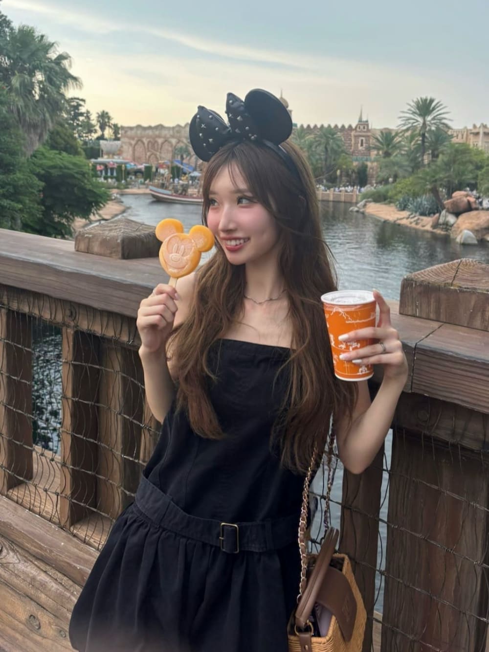 ブラック系のワンピース、ブラウン系のブーツを着用したレディースの夏コーディネートの2枚目の写真