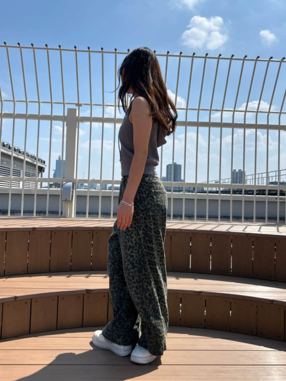 グリーン系のデニムパンツ、グレー系のニット/セーターを着用したレディースの秋コーディネートの2枚目の写真