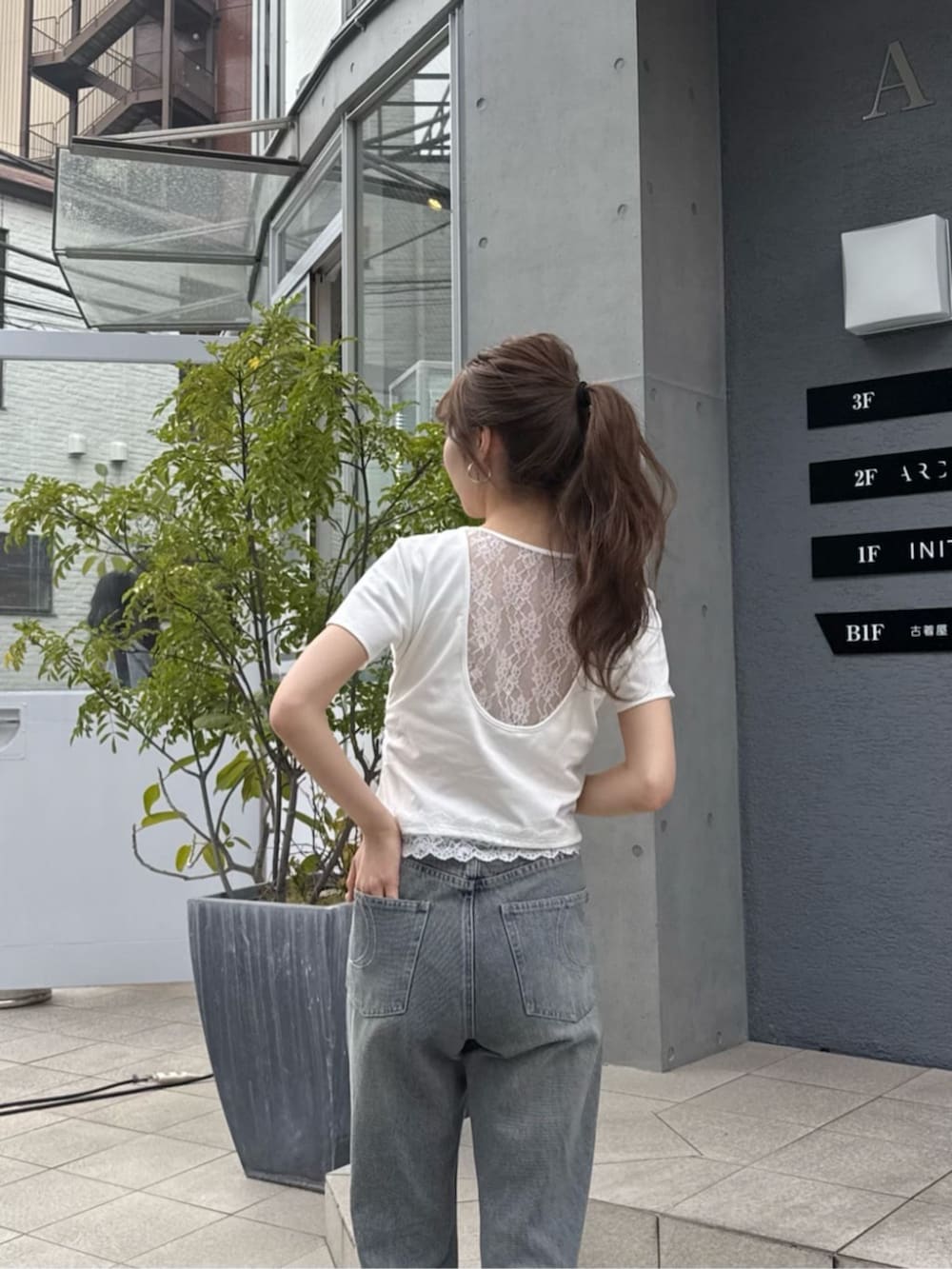 ブルー系のデニムパンツ、ホワイト系のTシャツ/カットソー、ホワイト系のサンダルを着用したレディースの夏コーディネートの2枚目の写真