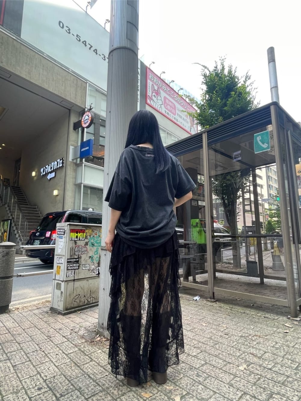 ブラック系のTシャツ/カットソー、ブラック系のスカート、ブラウン系のブーツを着用したレディースの夏コーディネートの2枚目の写真