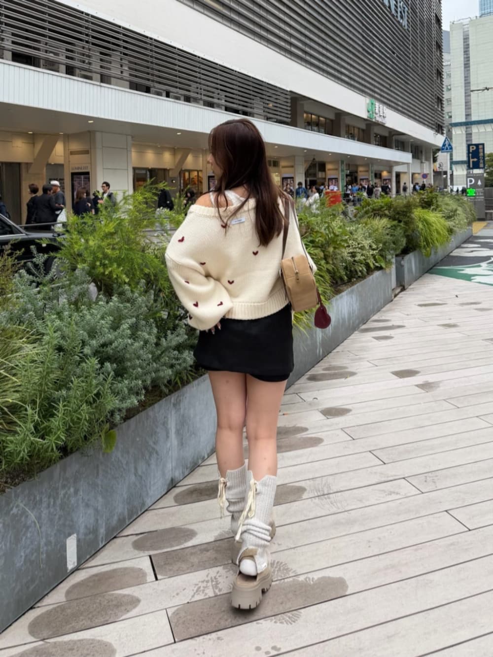 ブラック系のスカート、ホワイト系のカーディガン/ボレロを着用したレディースの秋コーディネートの3枚目の写真