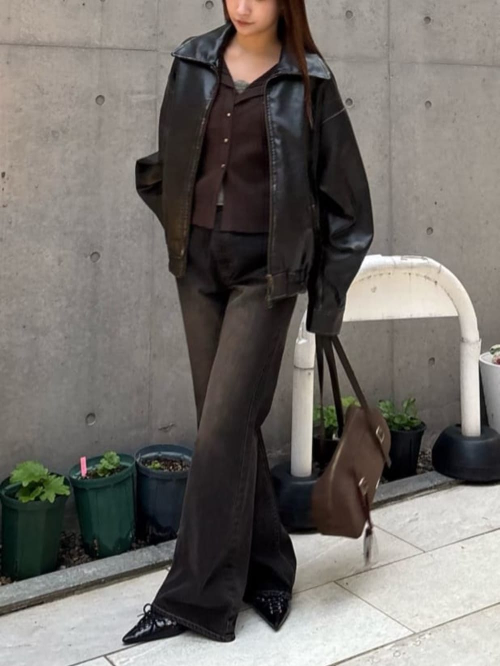 ブラック系のブルゾン、ブラック系のデニムパンツ、ブラウン系のニット/セーターを着用したレディースの冬コーディネートの2枚目の写真