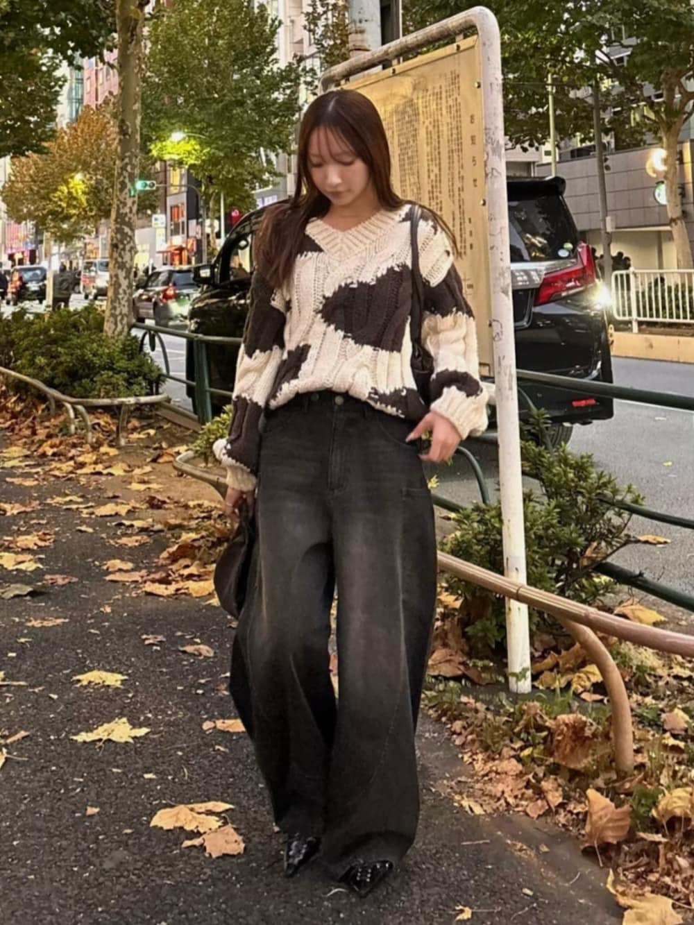 ブラック系のデニムパンツ、ホワイト系のニット/セーター、ブラック系のデニムパンツを着用したレディースの冬コーディネートの3枚目の写真