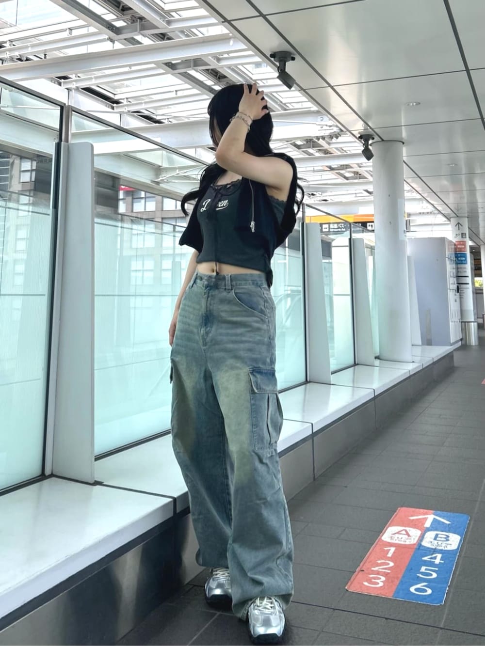 グレー系のキャミソール、ブラック系のTシャツ/カットソー、ブルー系のデニムパンツを着用したレディースの夏コーディネートの3枚目の写真