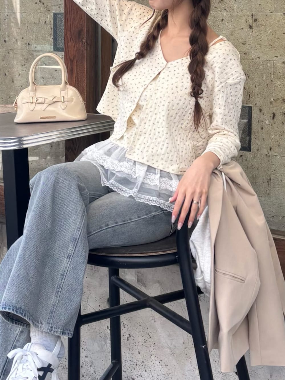 ブルー系のデニムパンツ、ホワイト系のサンダル、ホワイト系のカーディガン/ボレロを着用したレディースの春コーディネートの3枚目の写真