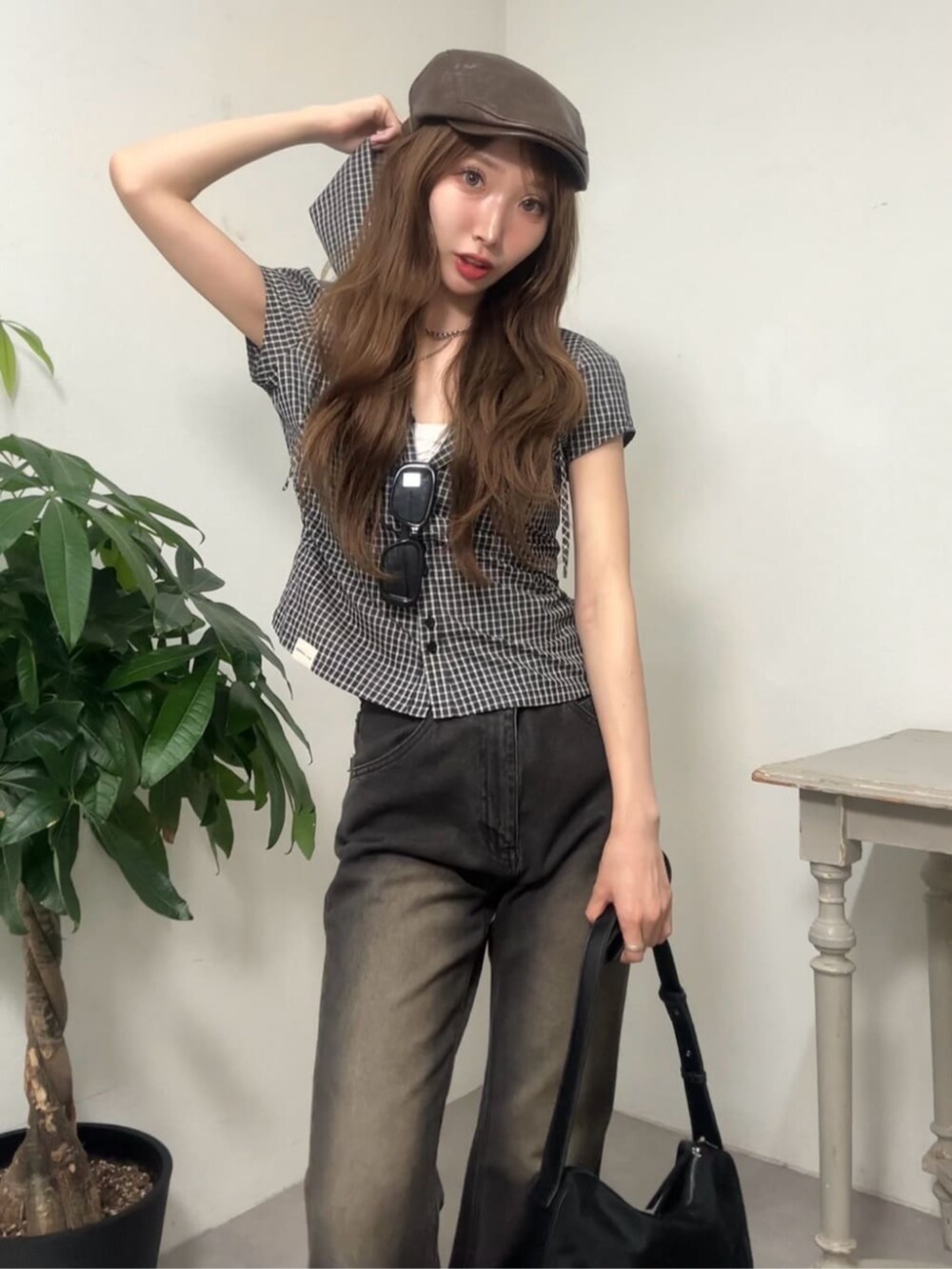 ブラウン系のデニムパンツ、ブラック系のシャツ/ブラウス、ブラウン系のハンチング/ベレー帽を着用したレディースの夏コーディネートの3枚目の写真