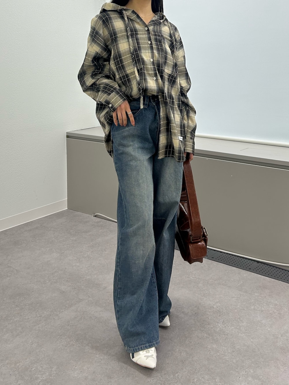 ブラック系のシャツ/ブラウス、ブルー系のデニムパンツ、ホワイト系のサンダルを着用したレディースの冬コーディネートの2枚目の写真