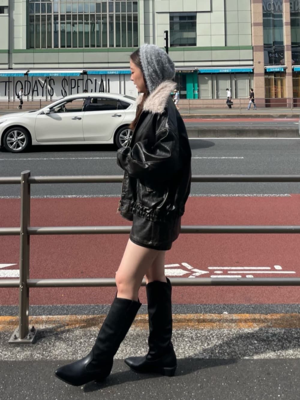 ブラック系のブーツ、ブラウン系のスカート、グレー系のニット/セーターを着用したレディースの秋コーディネートの2枚目の写真