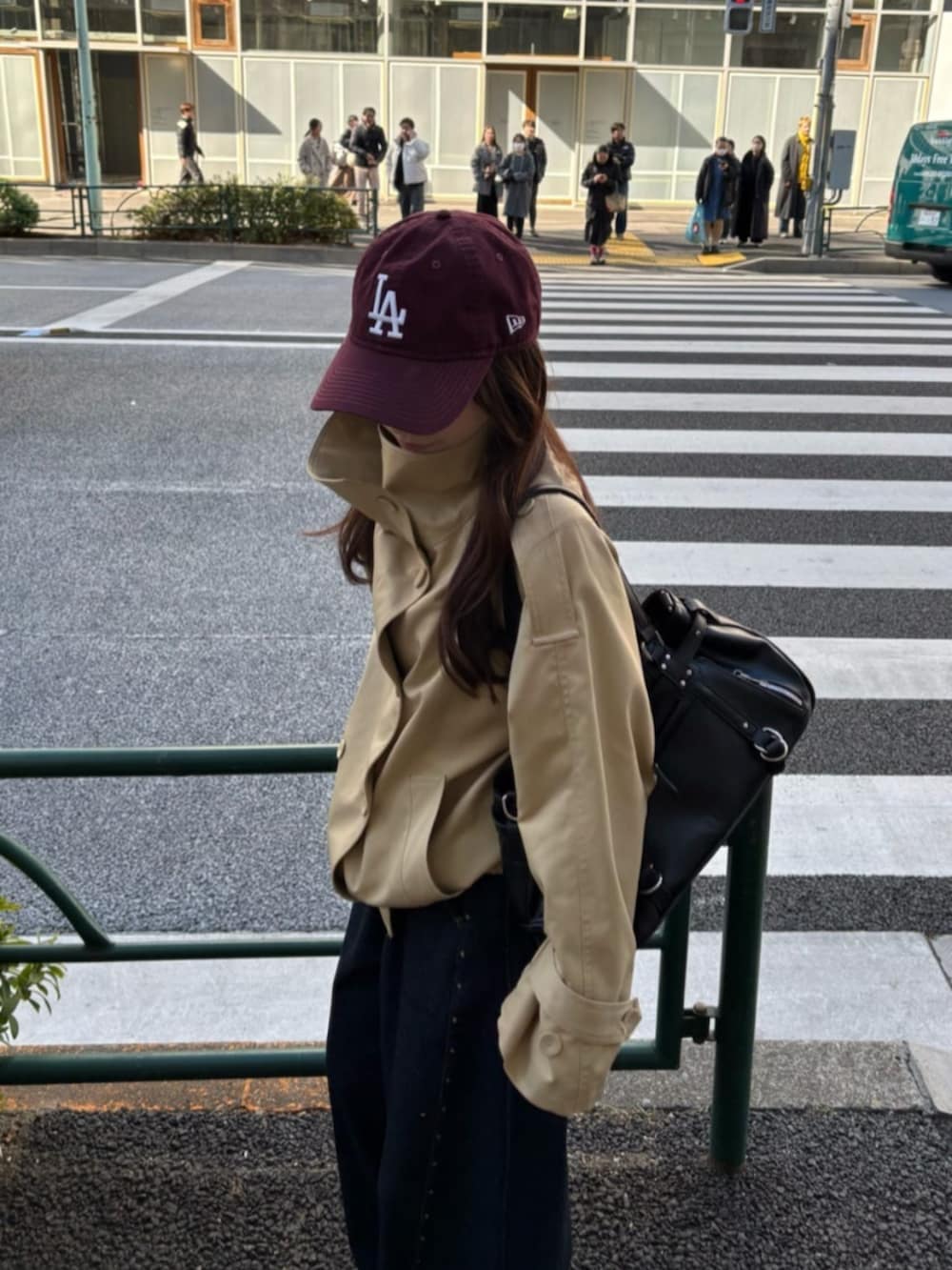 ベージュ系のトレンチコート、ブルー系のデニムパンツを着用したレディースの冬コーディネートの3枚目の写真